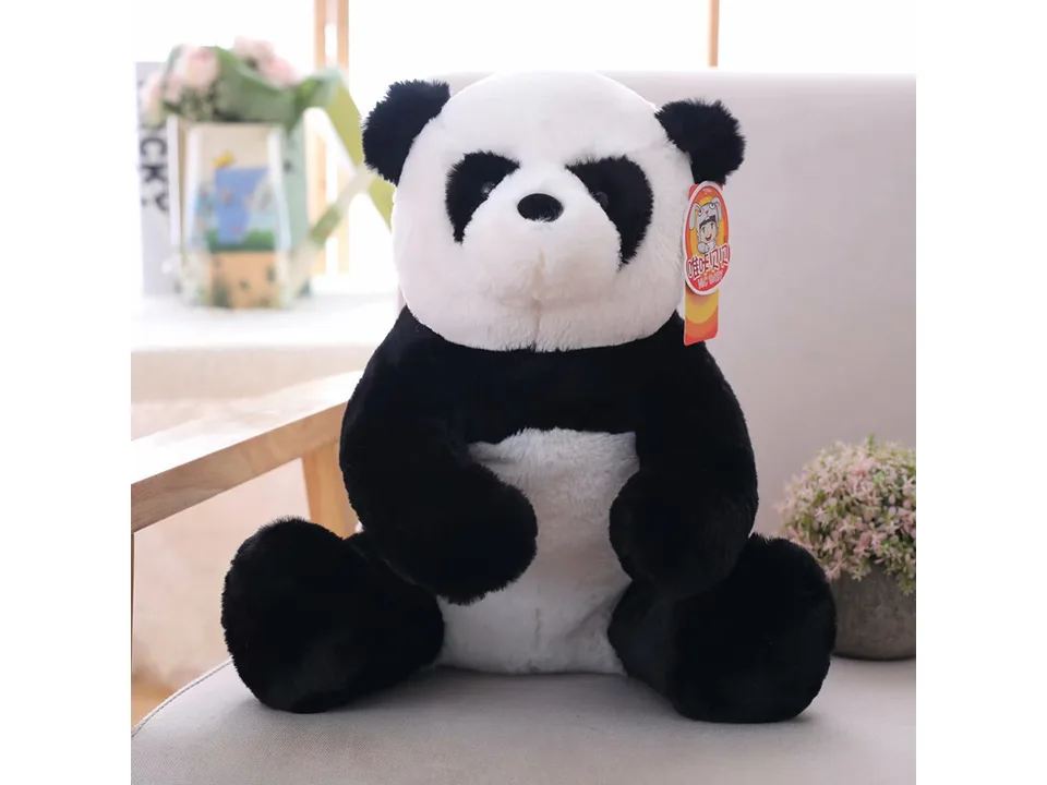 A plush panda toy sitting on a chair.
