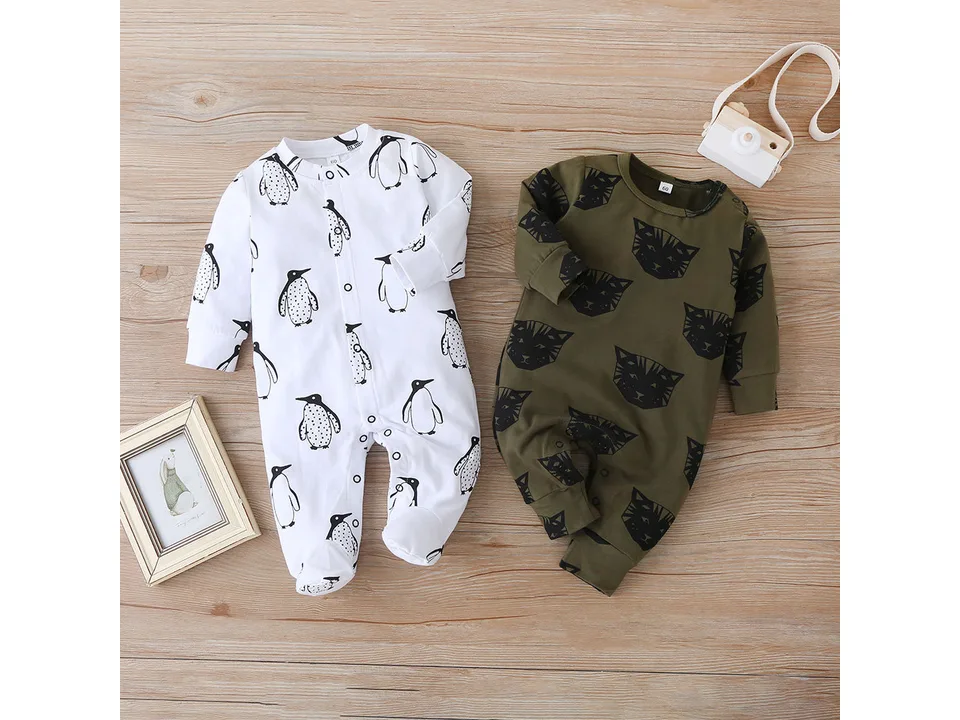 Two baby jumpsuits laid flat, one white with penguin print and one olive green with cat print.