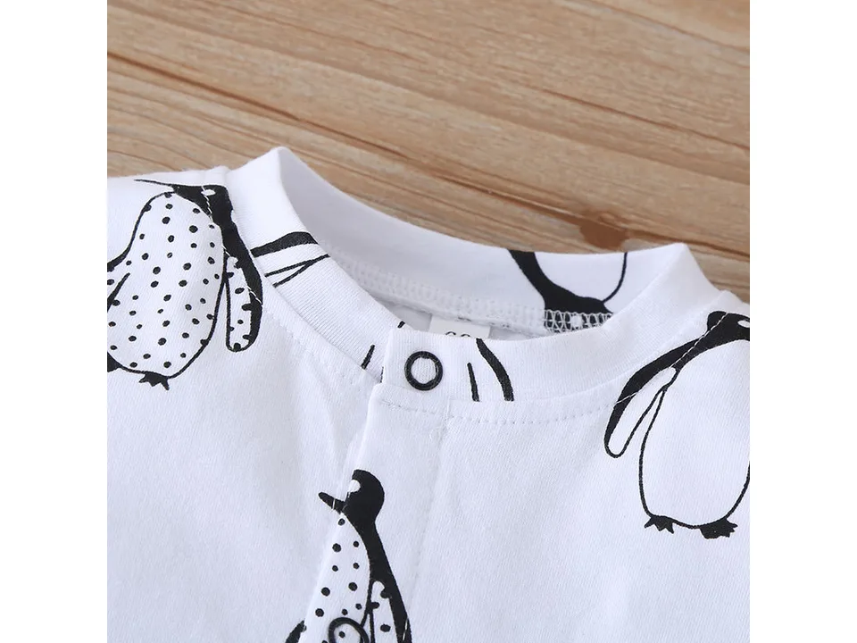 Close-up of the neckline and collar of the white penguin-print baby jumpsuit.