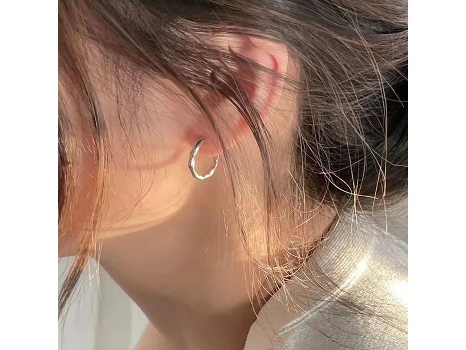 Side profile of a person wearing the silver hoop earring.