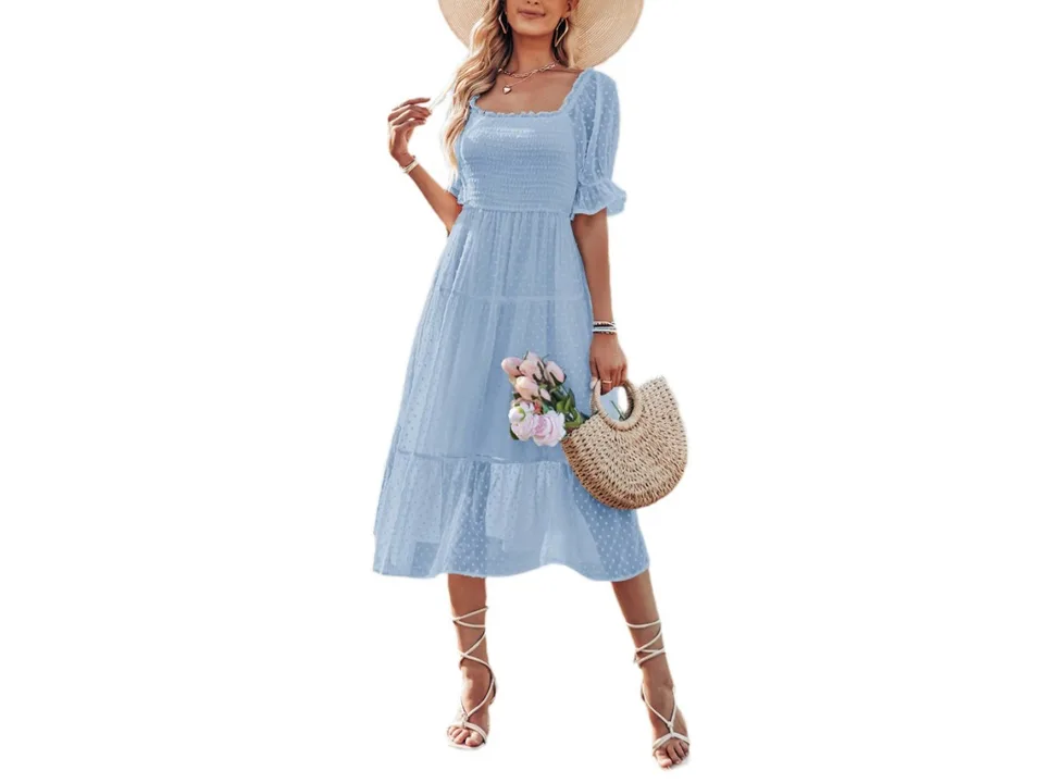A woman wearing a light blue square neck midi dress with short sleeves and a tiered skirt.