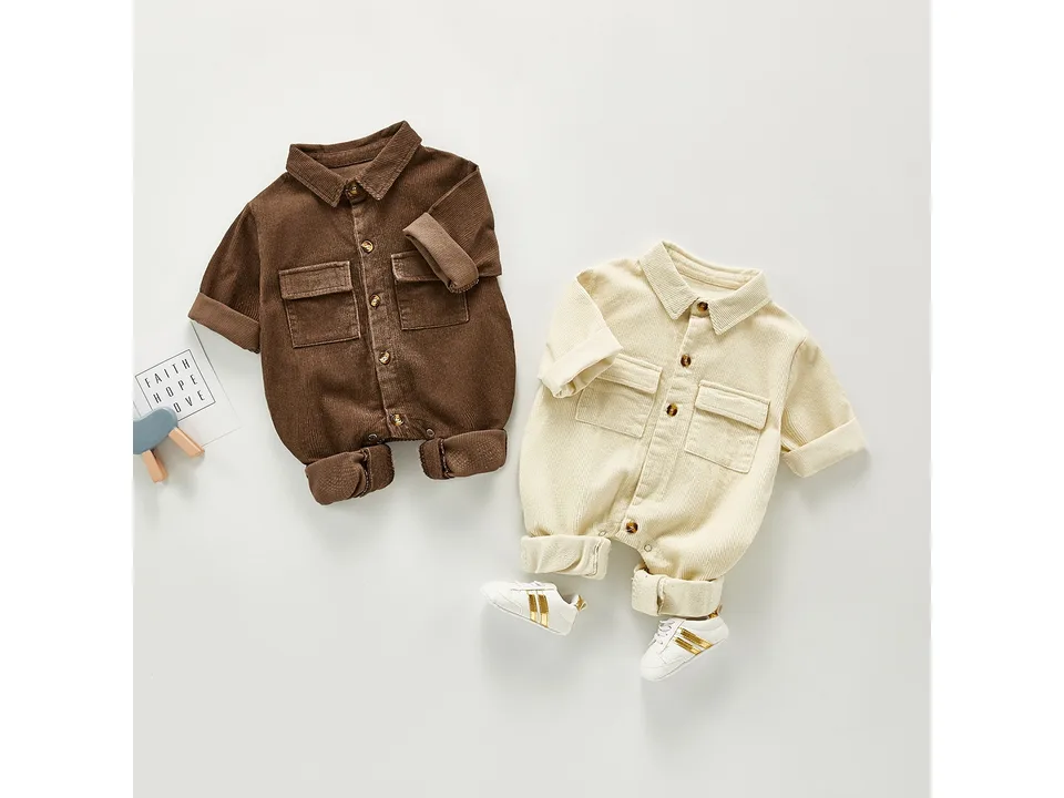 Brown and cream baby corduroy rompers with a pair of small white sneakers.