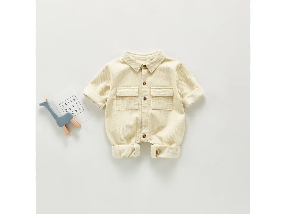 Front view of the cream baby corduroy romper with button-up front and chest pockets.