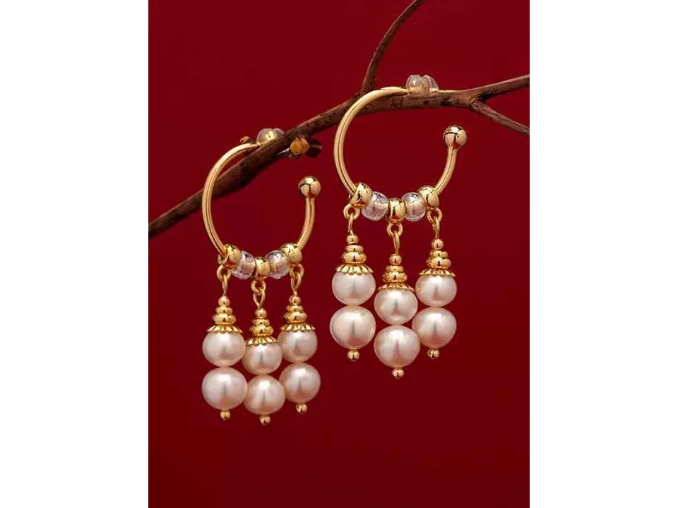 Pair of gold hoop earrings with pearl dangles hanging from a small branch.