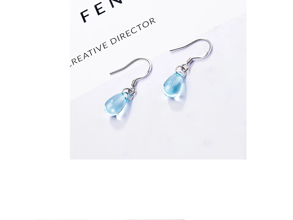 Pair of blue crystal drop earrings on a white surface.