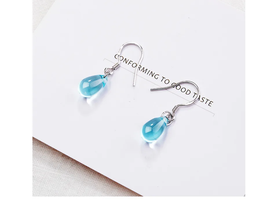 Close-up of blue crystal drop earrings on a white background.