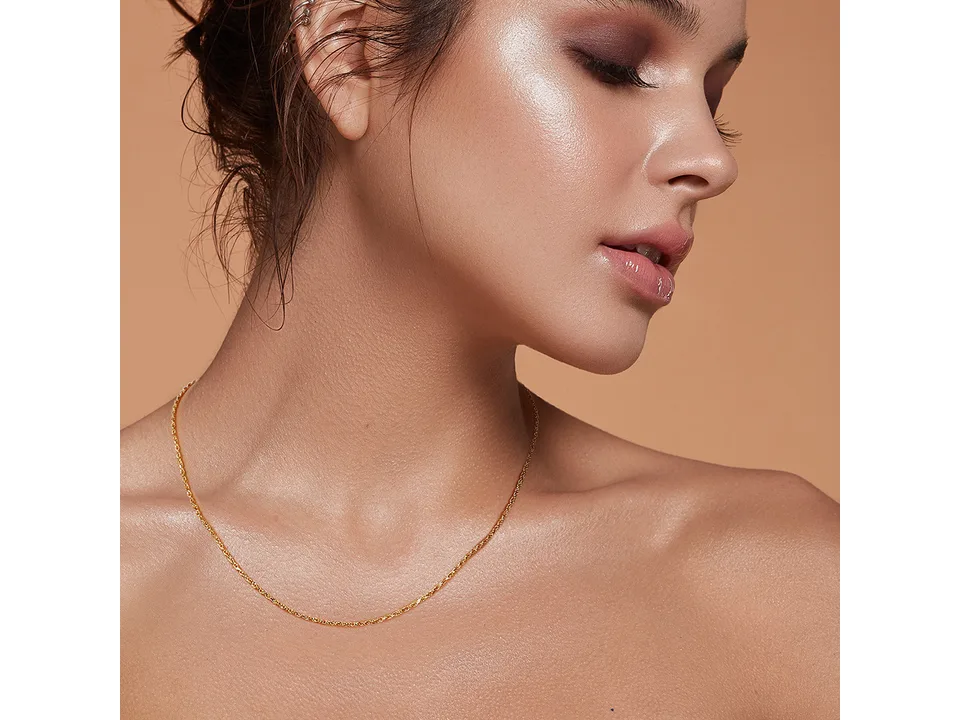 A woman wearing a gold-toned rope chain necklace.