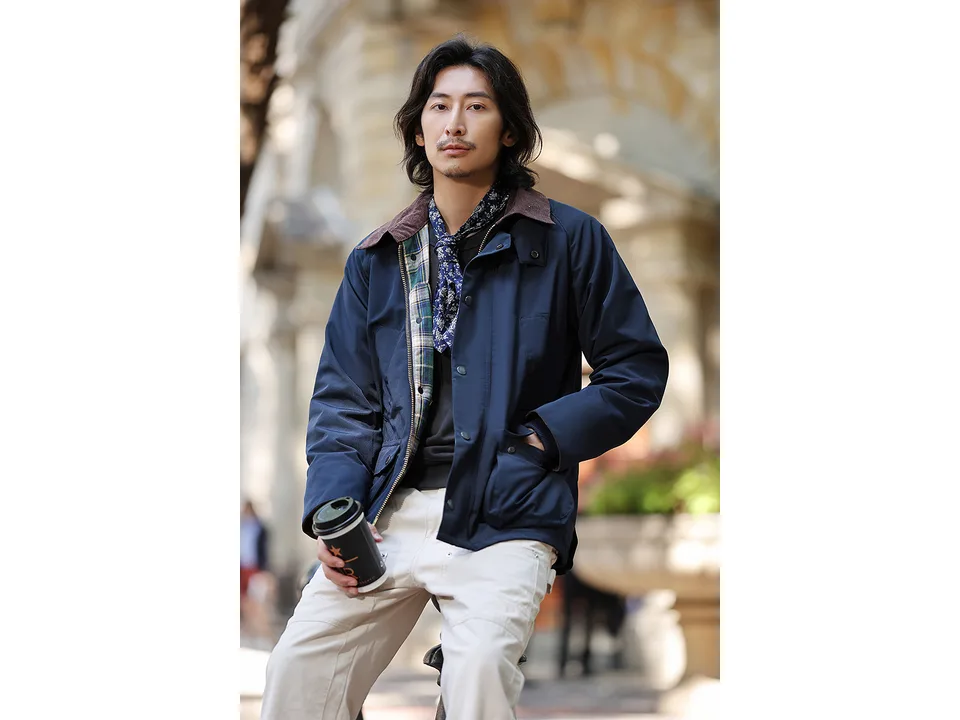 A man wearing the navy blue field jacket, showing the fit and corduroy collar.