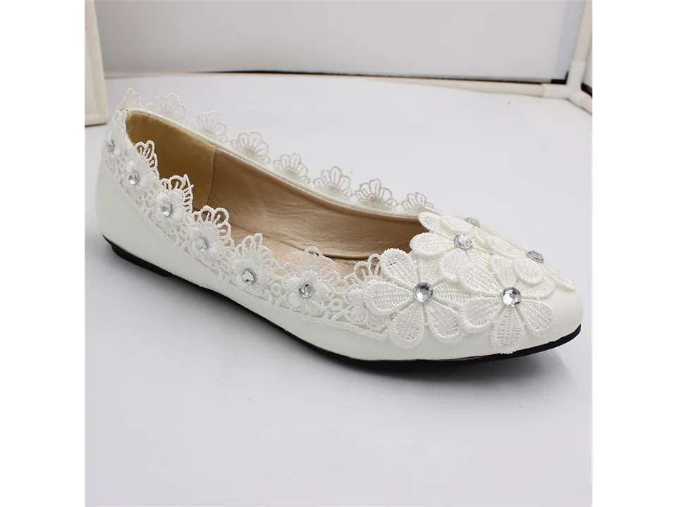 A single white lace flat shoe with rhinestone floral embellishments.