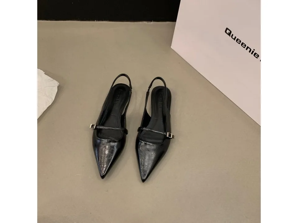 A pair of black pointed toe slingback sandals with a buckle strap.
