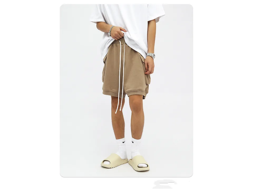 A person wearing beige cargo shorts with a white t-shirt and slides.
