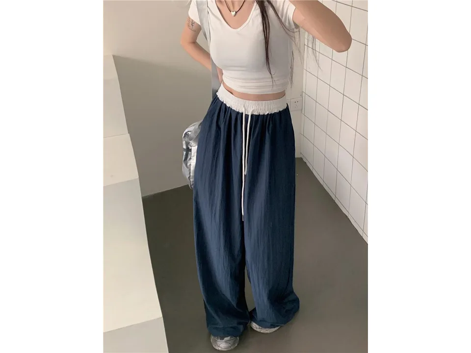 Close-up of the wide-leg trousers showing the elastic waistband and drawstring.