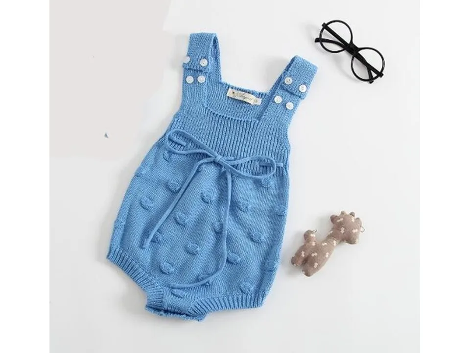 Blue baby knit romper with tie detail and textured dots.