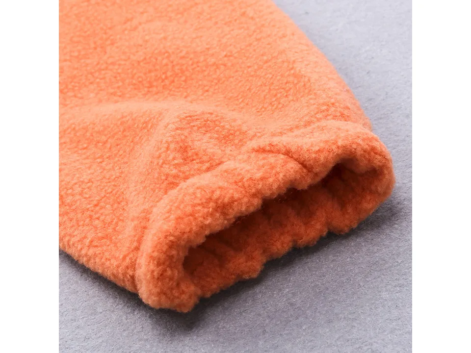 Close-up of the elasticated cuff on the sleeve of an orange fleece baby jumpsuit.