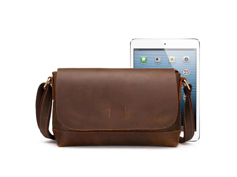 Brown leather messenger bag next to a tablet for scale