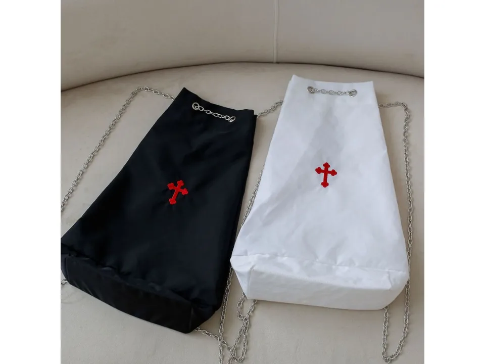 Black and white drawstring bags with red cross embroidery placed side-by-side.