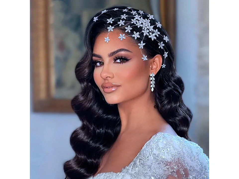 A bride wearing a decorative rhinestone flower hair comb.