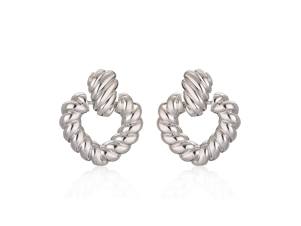 A pair of silver-tone twisted heart hoop earrings on a white background.