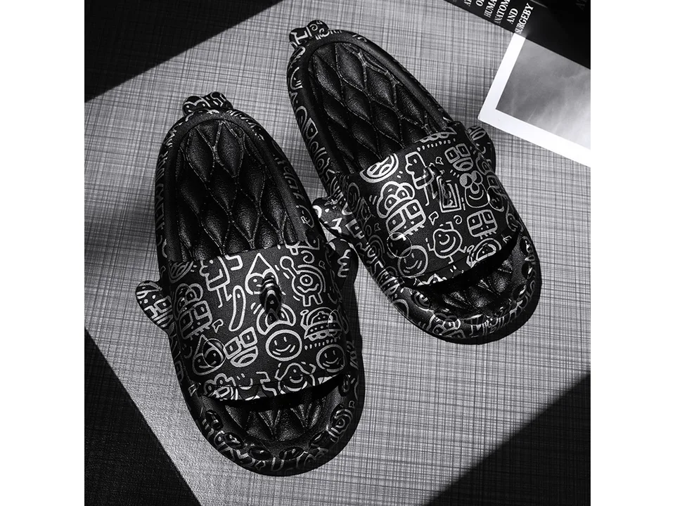 A pair of black shark-themed slides with white doodle patterns.