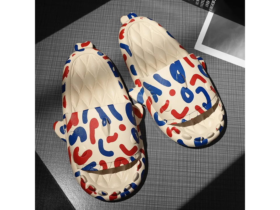 A pair of beige shark-themed slides with red and blue abstract patterns.