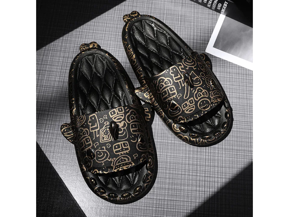 A pair of black shark-themed slides with gold doodle patterns.