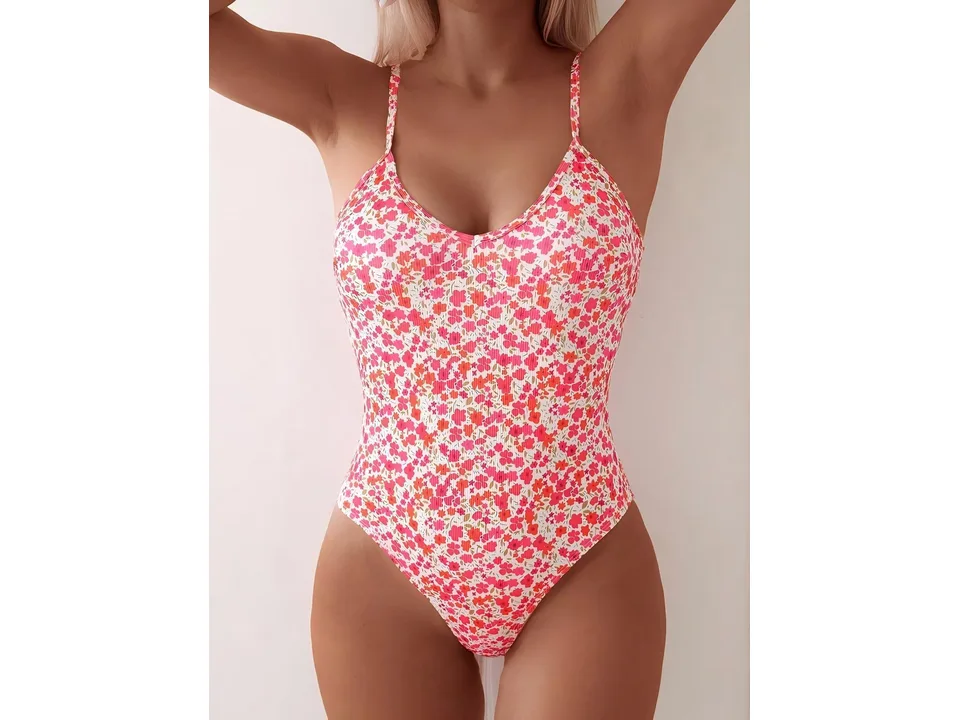 A woman wearing a floral print one-piece swimsuit.