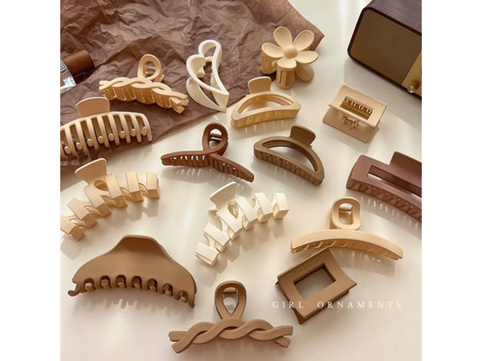 A collection of various matte and fuzzy hair claw clips arranged on a surface.
