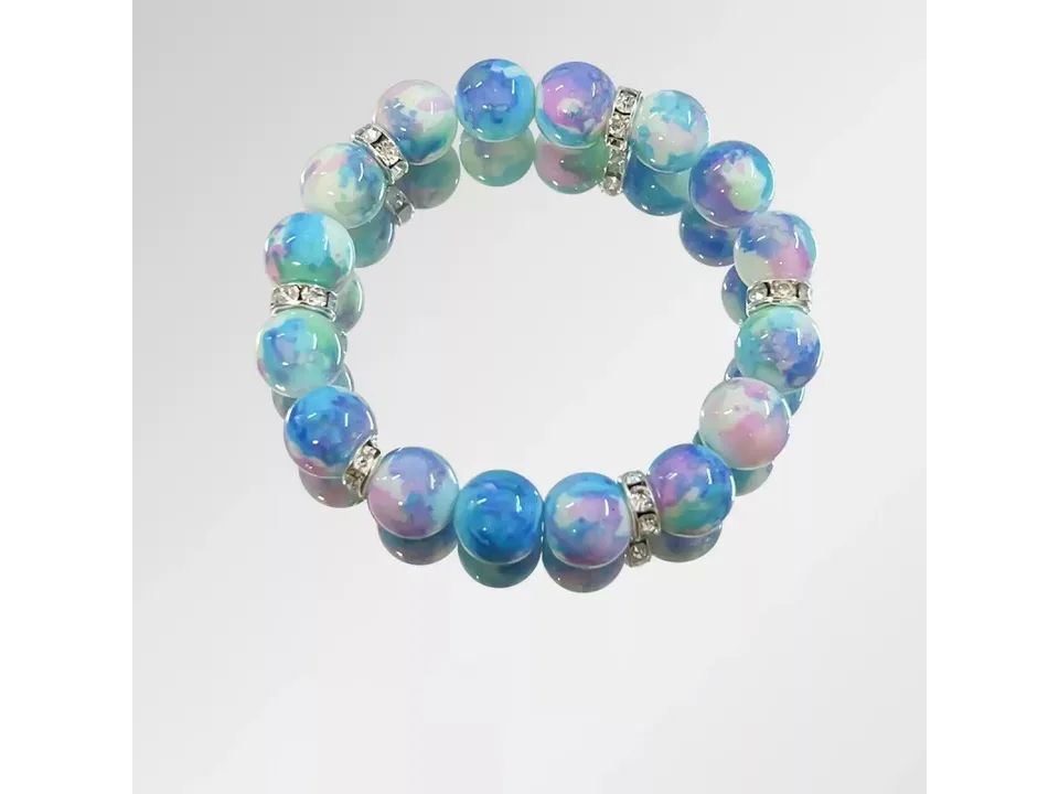 A blue and purple glass bead bracelet with rhinestone spacers on a white background.