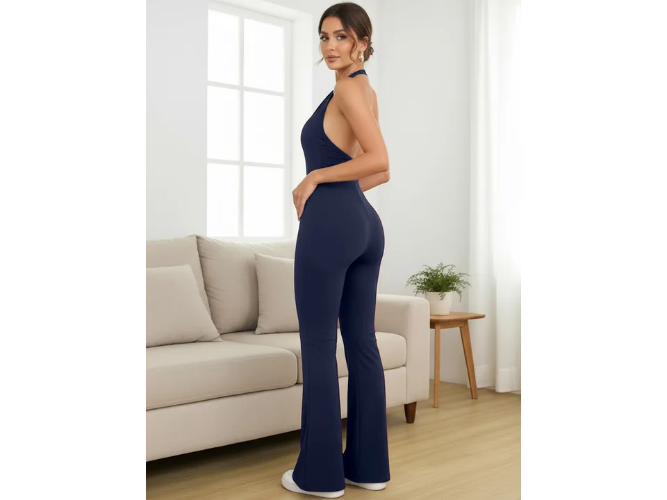 A woman wearing a navy blue sleeveless jumpsuit, viewed from the side.