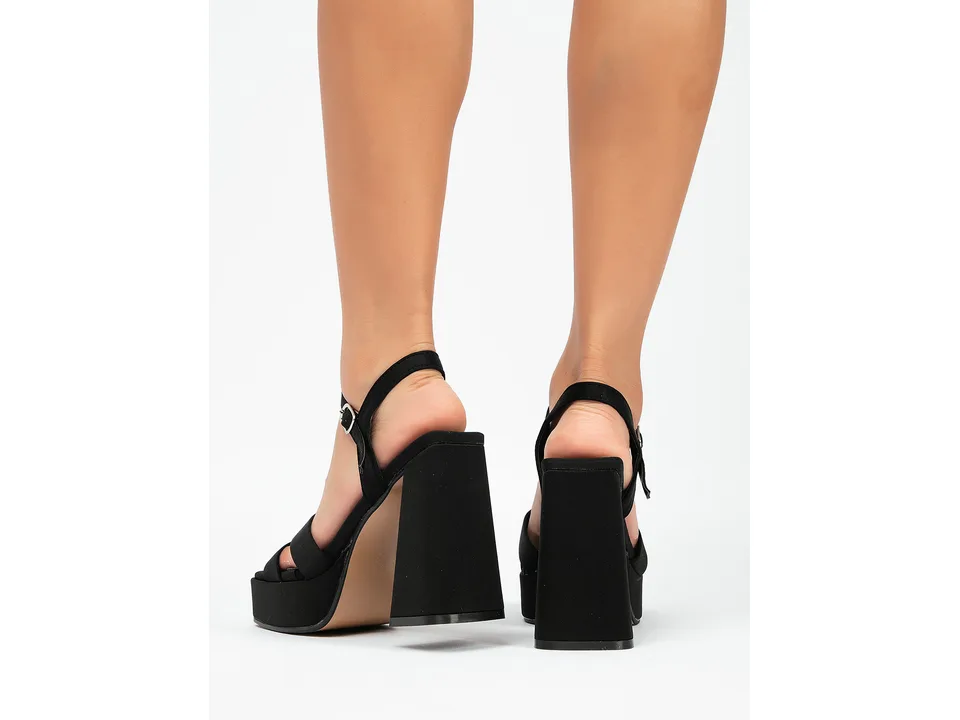 Close-up of the back of the black platform sandals being worn.