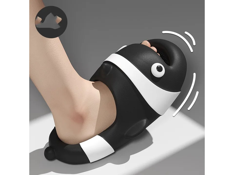 A close-up of a foot wearing a black clown fish slide, showing the flexible material.