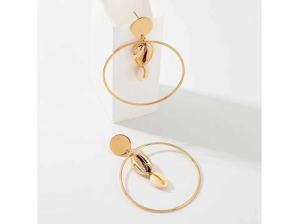 Two gold hoop earrings with shell dangles, one standing upright and one lying flat.