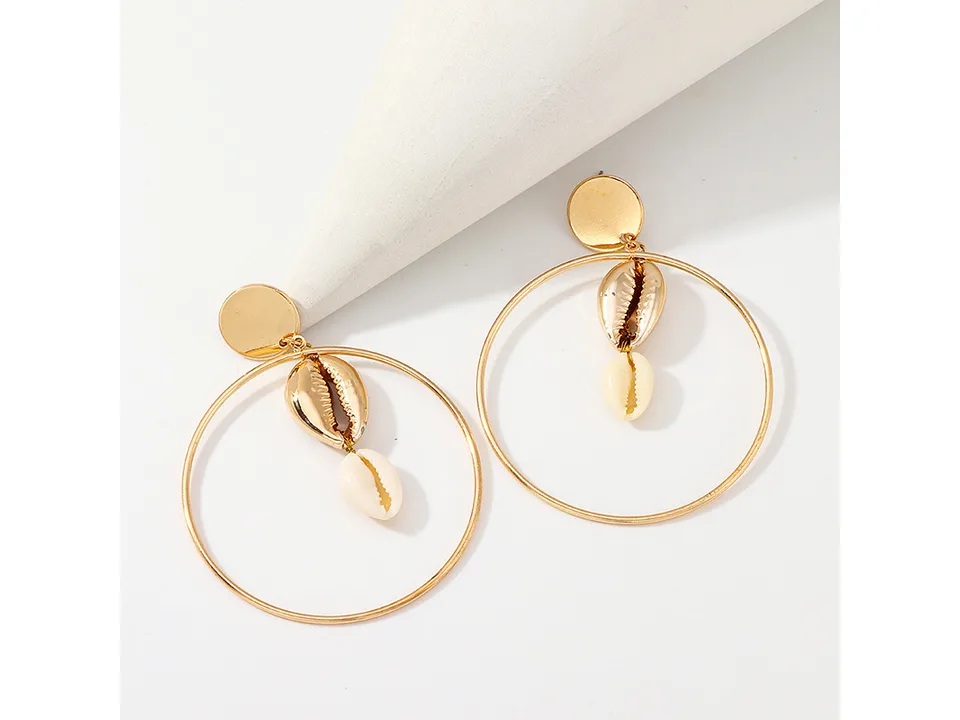 A pair of gold hoop earrings with a metallic shell and a natural shell dangle.