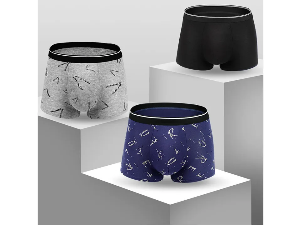 Three pairs of men's boxer shorts in grey, black, and navy with patterned designs.