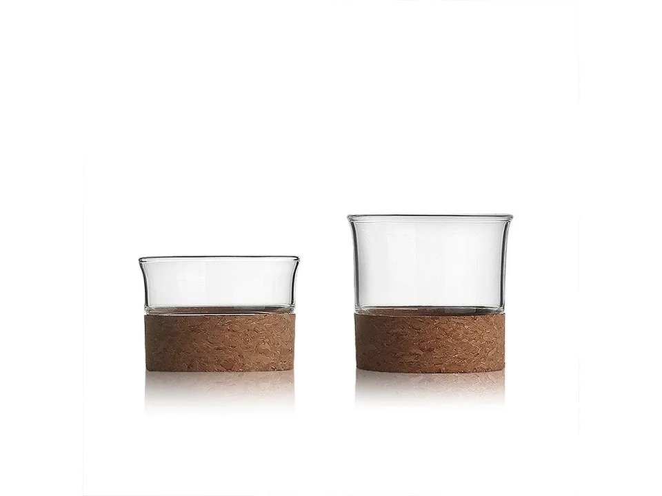 Two glass cups with cork bases of different sizes.