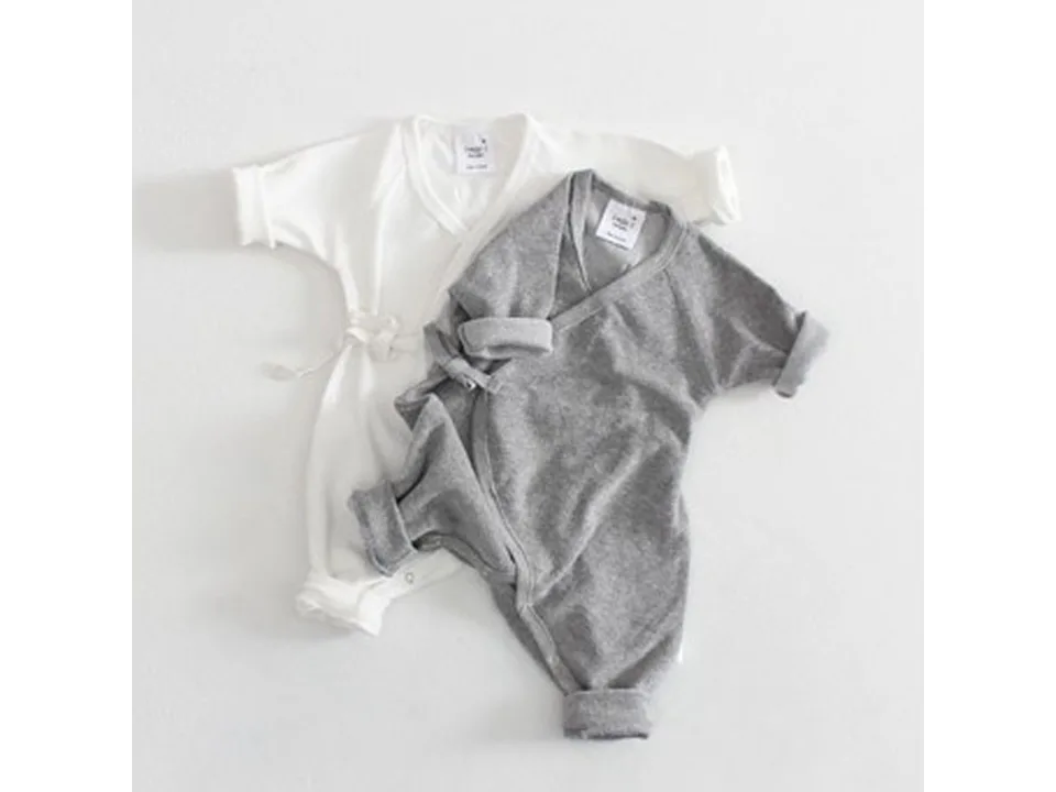 White and grey baby jumpsuits with wrap-around tie closure.
