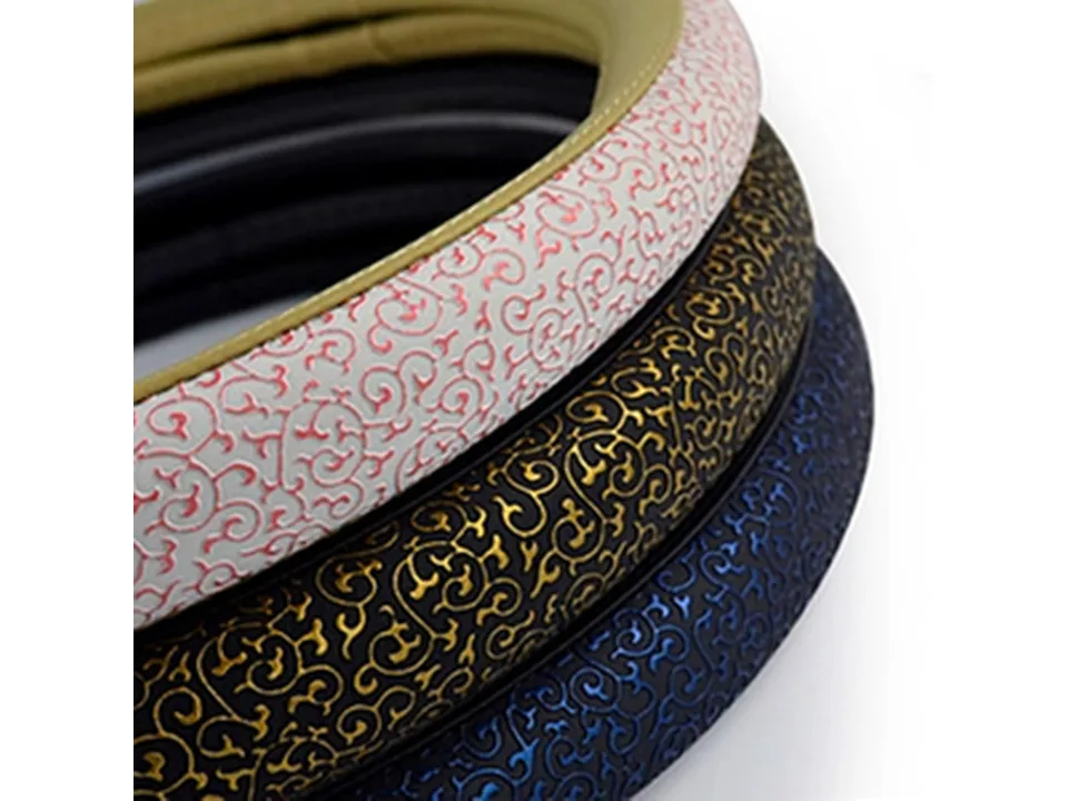 Three steering wheel covers stacked, showing white, gold, and blue swirl patterns.