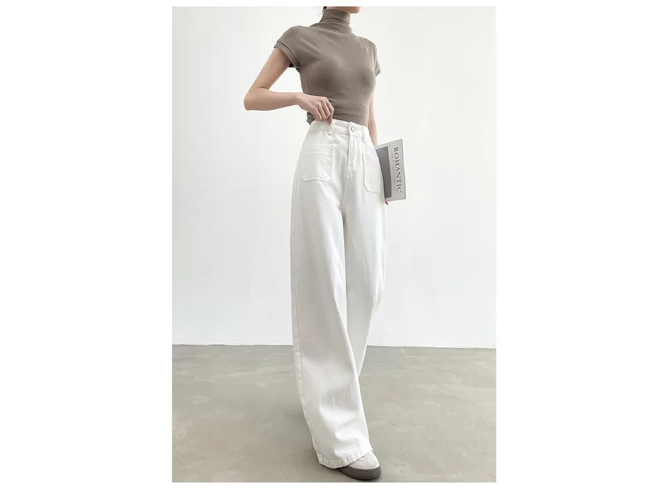 A woman wearing white high-waisted wide-leg denim pants with a brown short-sleeved top.