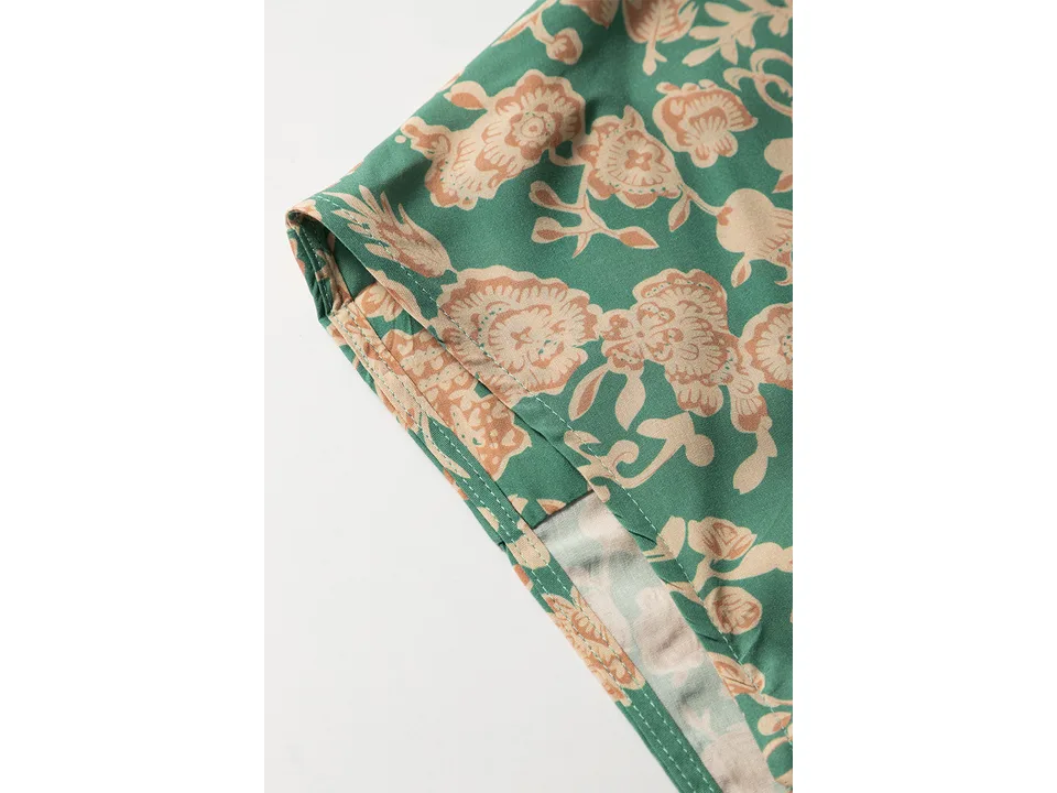 Close-up of the green and beige floral fabric pattern and stitching.