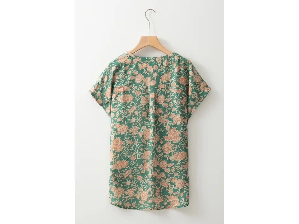 Back view of the green floral shirt on a hanger.