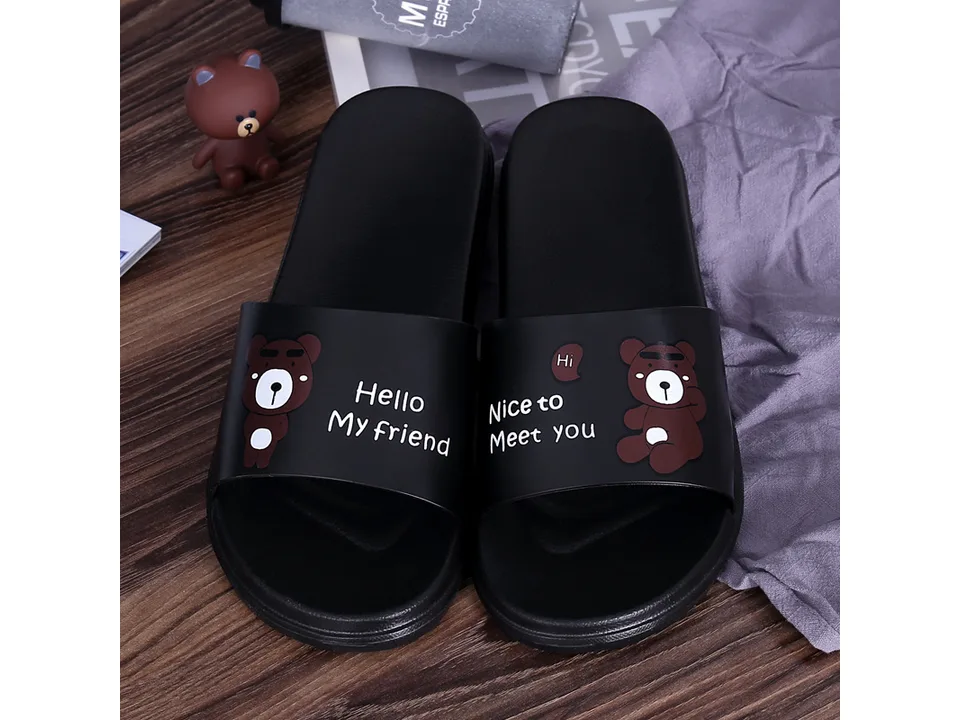 A pair of black cartoon bear slippers with 'Hello My friend' and 'Nice to Meet you' text.