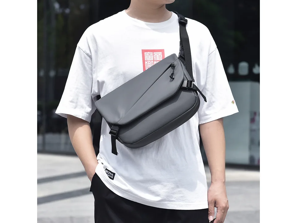 A person wearing the black crossbody bag over their shoulder.