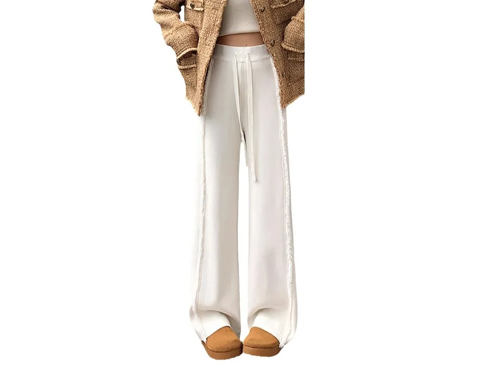 Full-length view of white high-waisted knitted trousers.