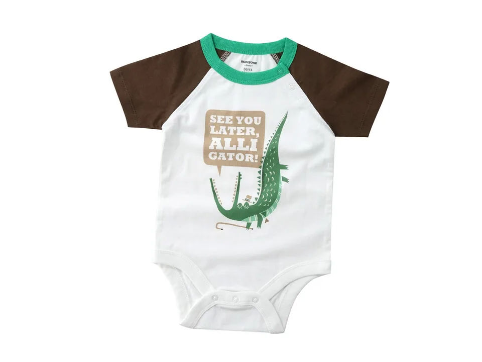 A white baby romper with an alligator graphic and brown sleeves.