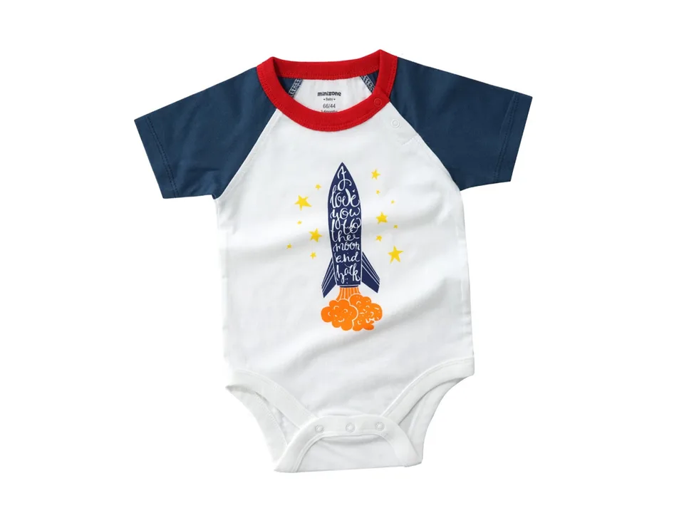 A white baby romper with a rocket ship graphic and blue sleeves.