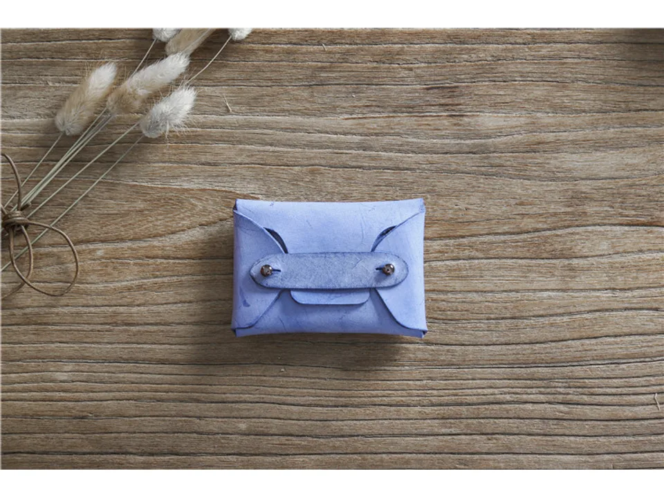 Blue leather card holder on a wooden surface.