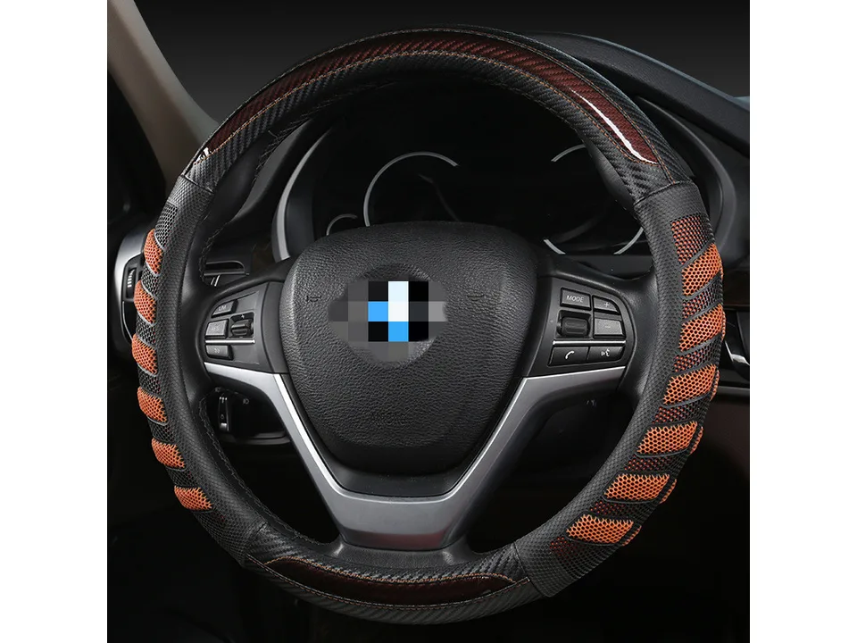Orange and black honeycomb steering wheel cover installed on a car steering wheel.