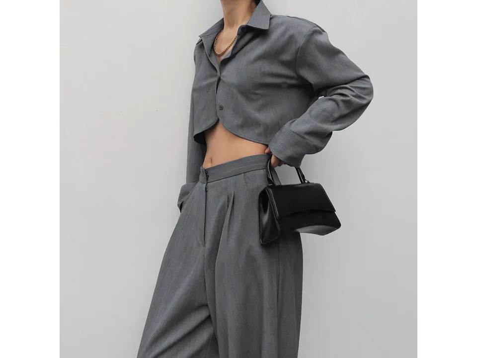 Side view of a model wearing the grey crop shirt and wide leg trousers.