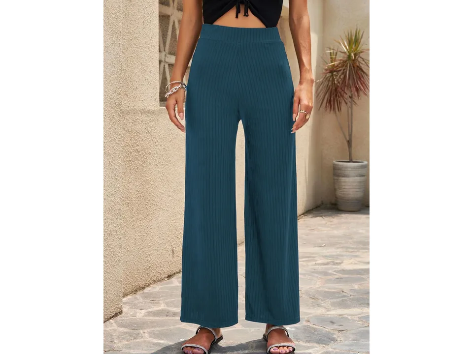 Front view of dark teal wide-leg ribbed pants on a model.