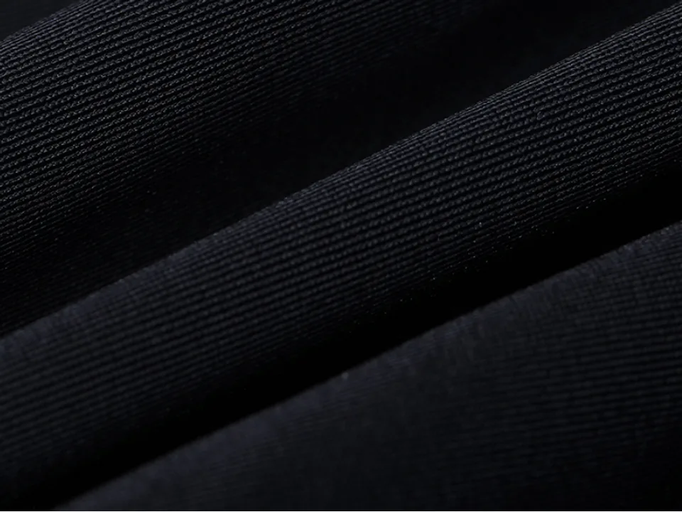 Close-up view of the black fabric texture of the swim trunks.